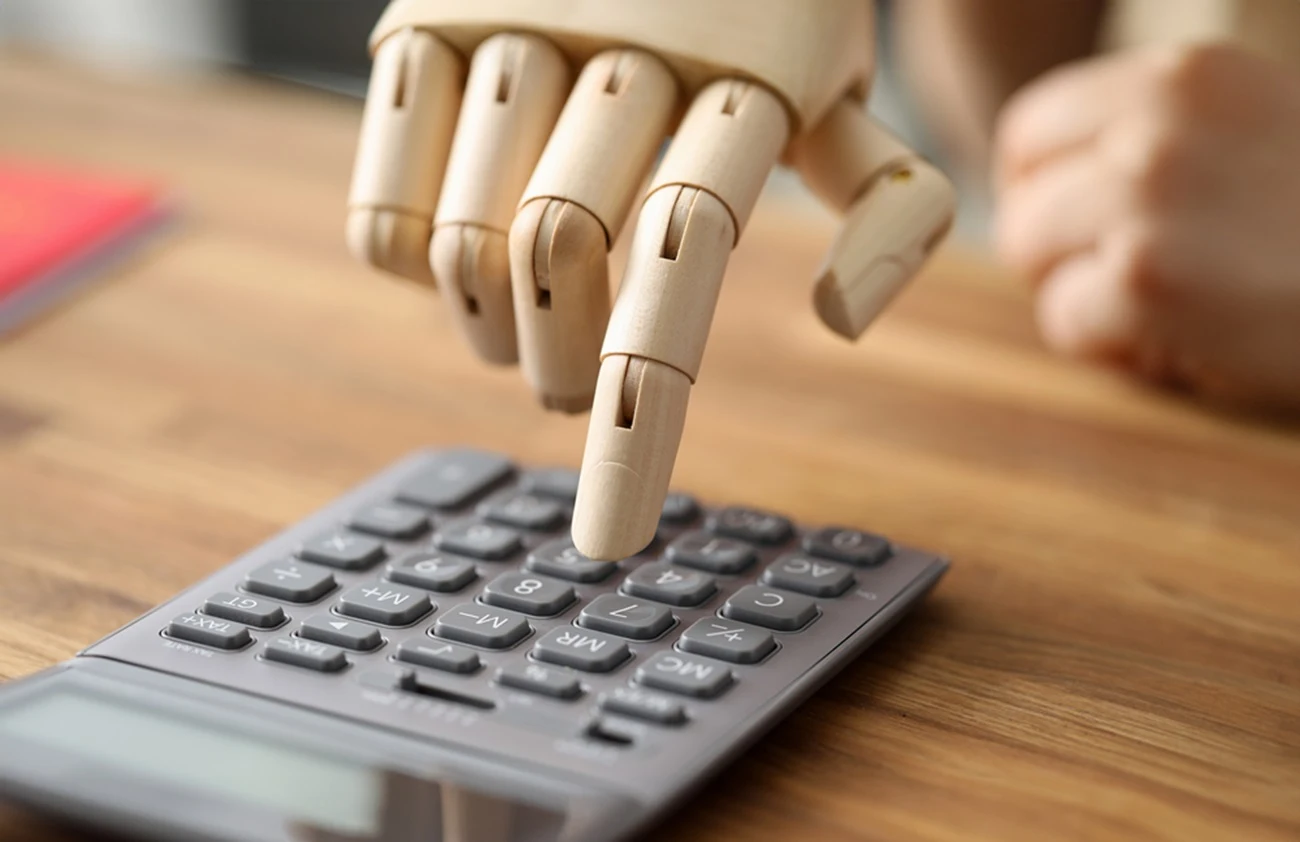 Prosthetic hand pressing the keys of a calculator