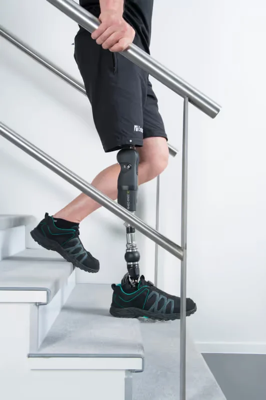 a man with a prosthetic goes down the stairs.